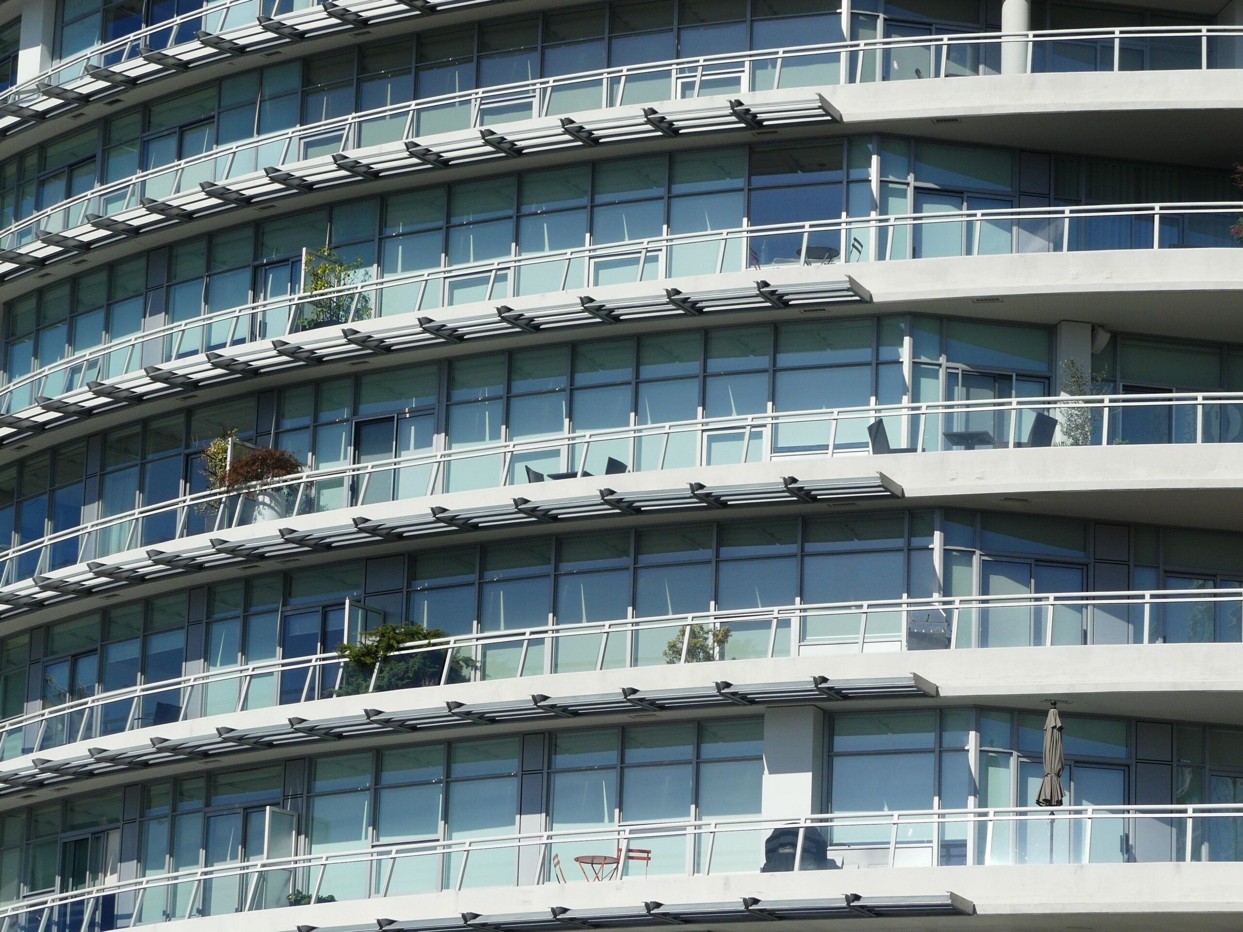 Close-up view of a modern apartment building with curved glass windows and balconies.